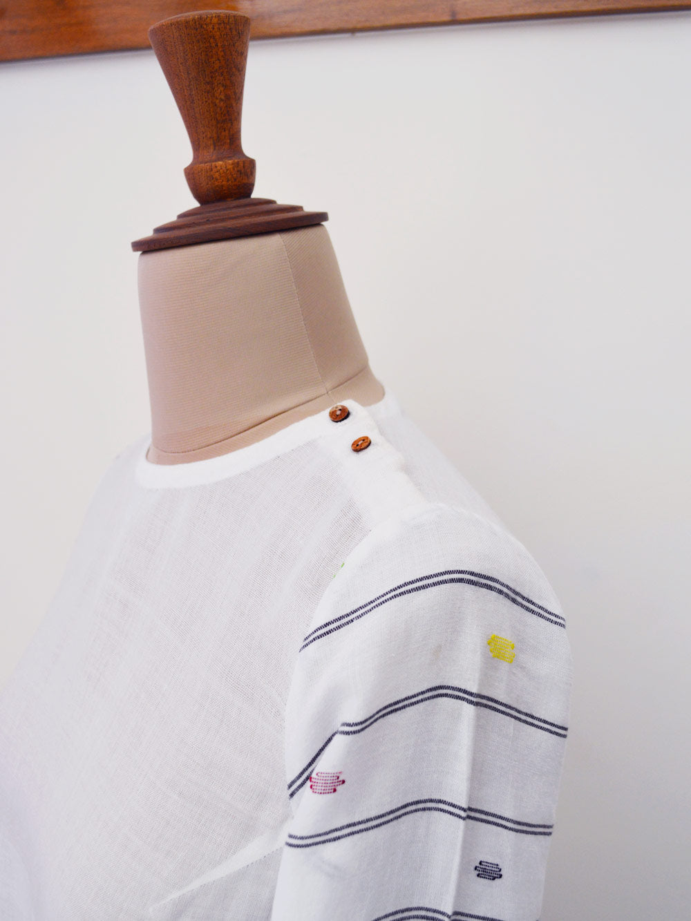 High low top with extra weft design and wooden button opening at the shoulder