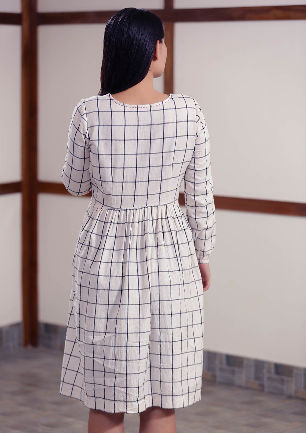 Back view of Checked peasant dress with running stitch design, designed by Khumanthem Atelier