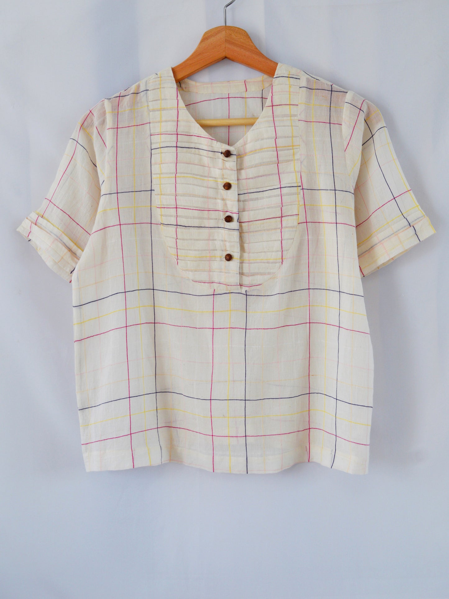 Front view of hanger shoot of Handwoven cotton top with pleated bib, designed by Khumanthem Atelier