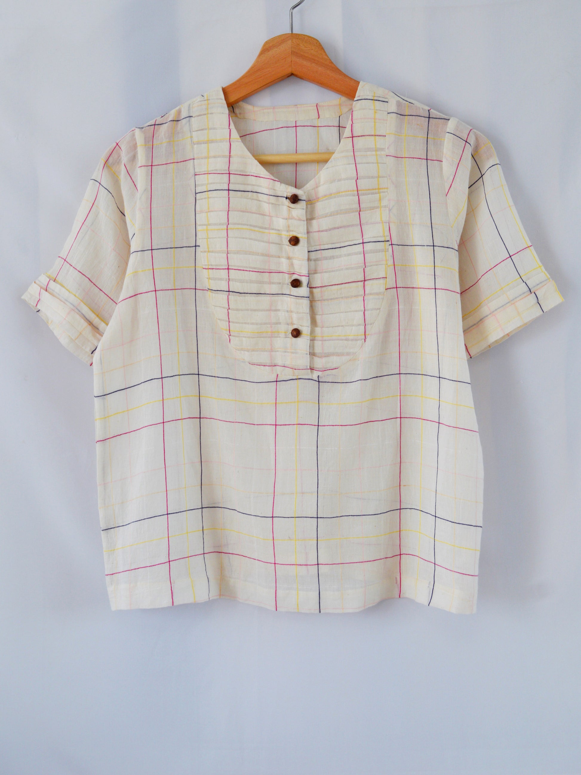Front view of hanger shoot of Handwoven cotton top with pleated bib, designed by Khumanthem Atelier