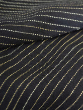 Load image into Gallery viewer, Close up view of the material of Front view of hanger shoot of Black and gold stripe tiered jacket designed by Khumanthem Atelier