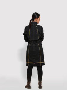 Back view of model posing wearing the Double Belt Pleated overcoat with black and golden stripes designed by Khumanthem Atelier