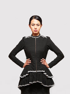Front view of model posing with Black and gold stripe High- low tiered Jacket with applique work designed by Khumanthem Atelier